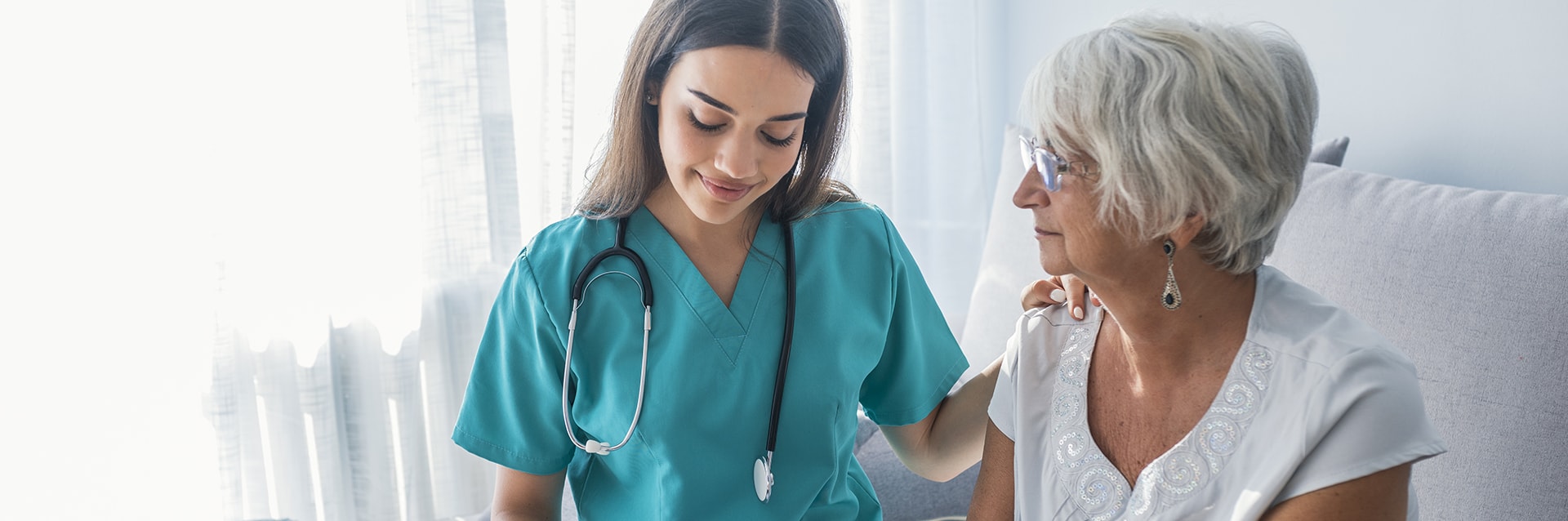 Nurse measuring blood pressure of senior woman at home