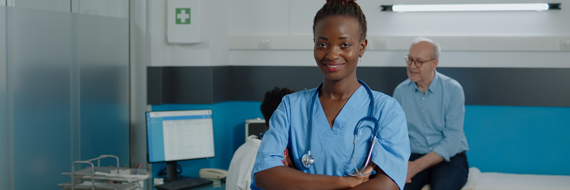 Young adult healthcare assistant with stethoscope smiling at medical clinic in doctors office