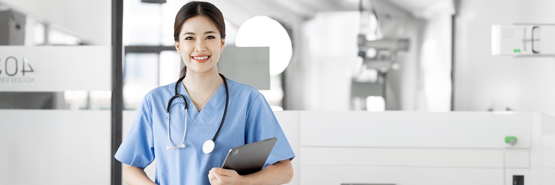 Female medical assistant with tablet in clinic