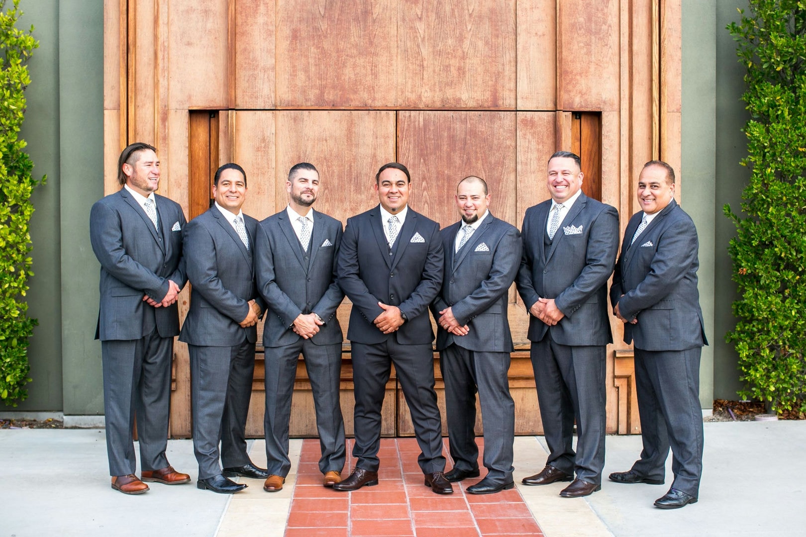 Group of men in dark suits standing outdoors.