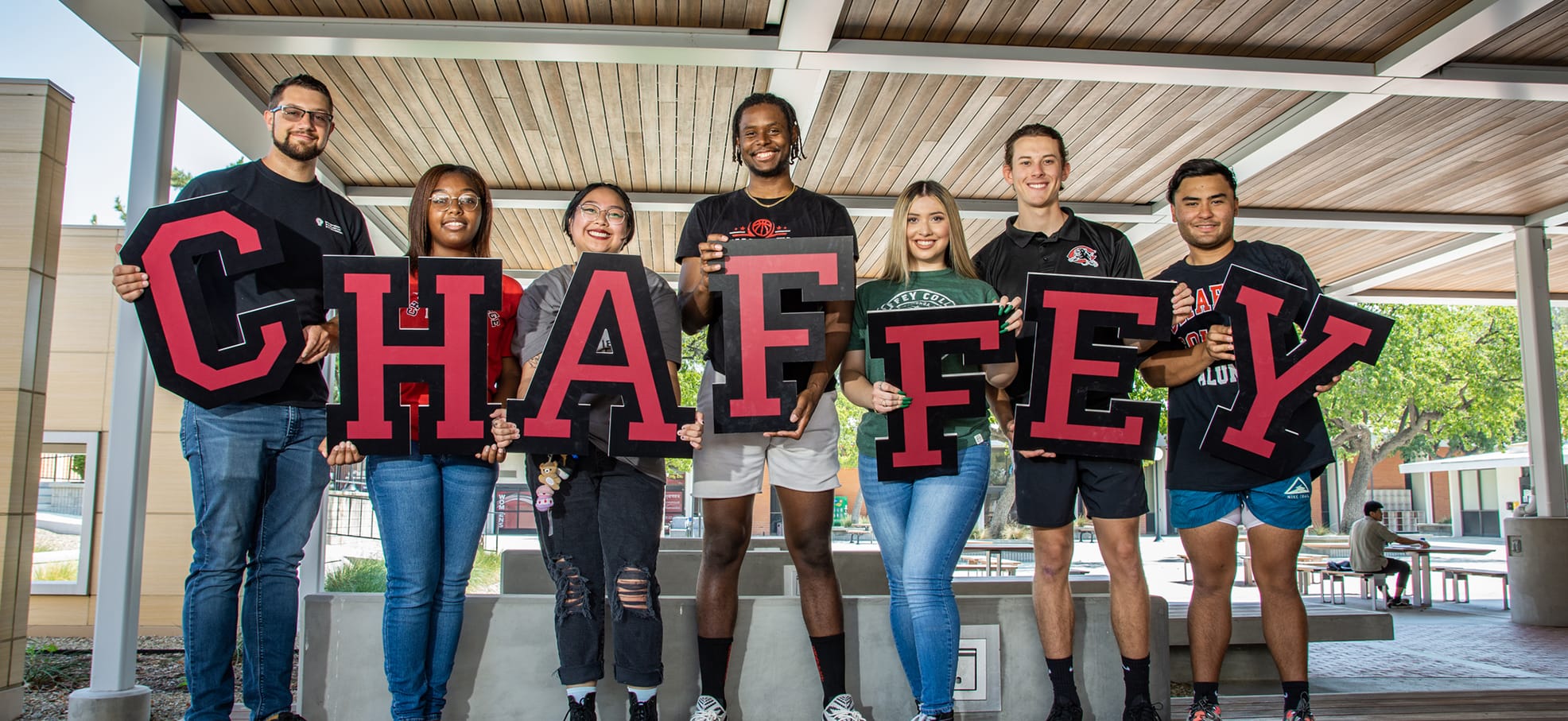 Student smiling and holding alphabet letters that read Chaffey