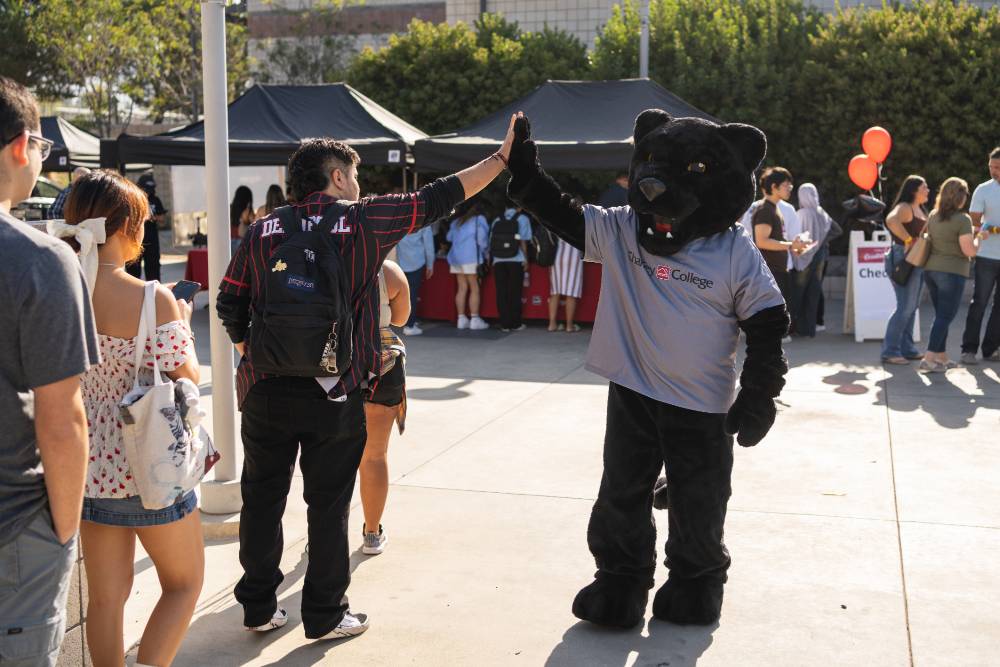 Rocky gives a student a high five