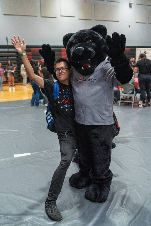 A student poses with Rocky at Orientation Day