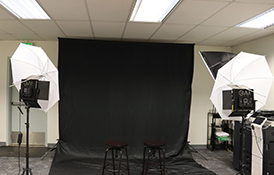 A person is being photographed in a studio setting.