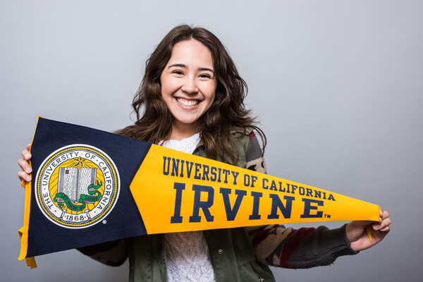 Student holding UCI pennant